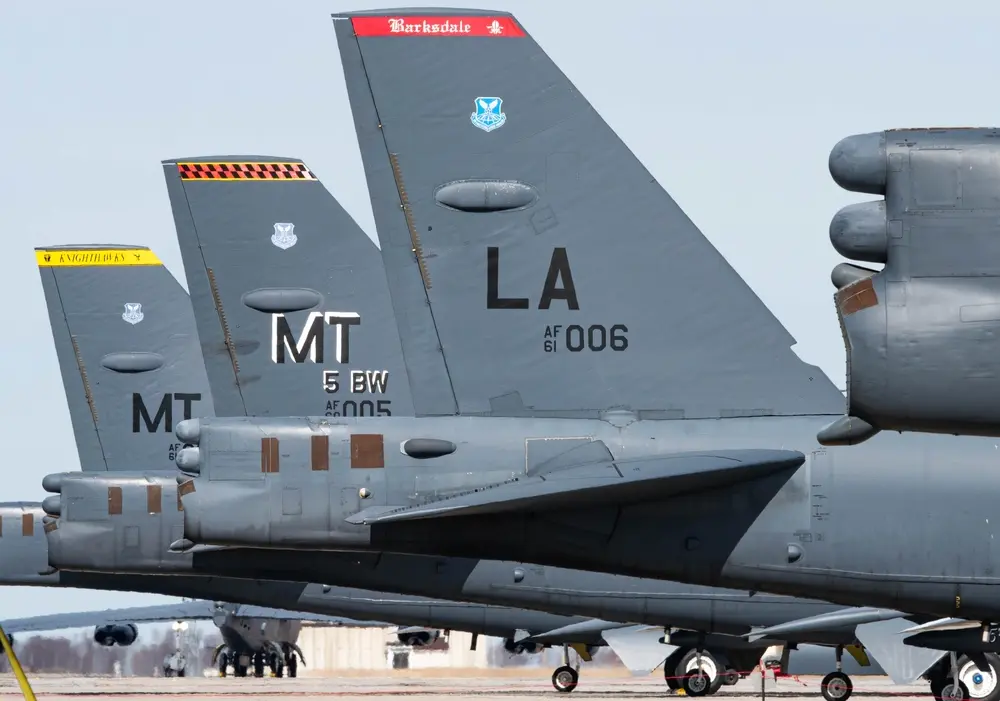 B-52 Stratofortress bombers with visible tail codes from Barksdale Air Force Base and Minot Air Force Base lined up on the runway