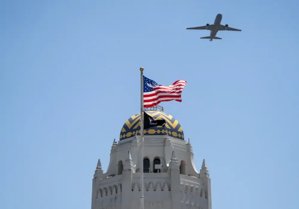 American flag flying atop the historic Taj Mahal Administration Building with an airplane overhead at JBSA-Randolph in San Antonio, Texas