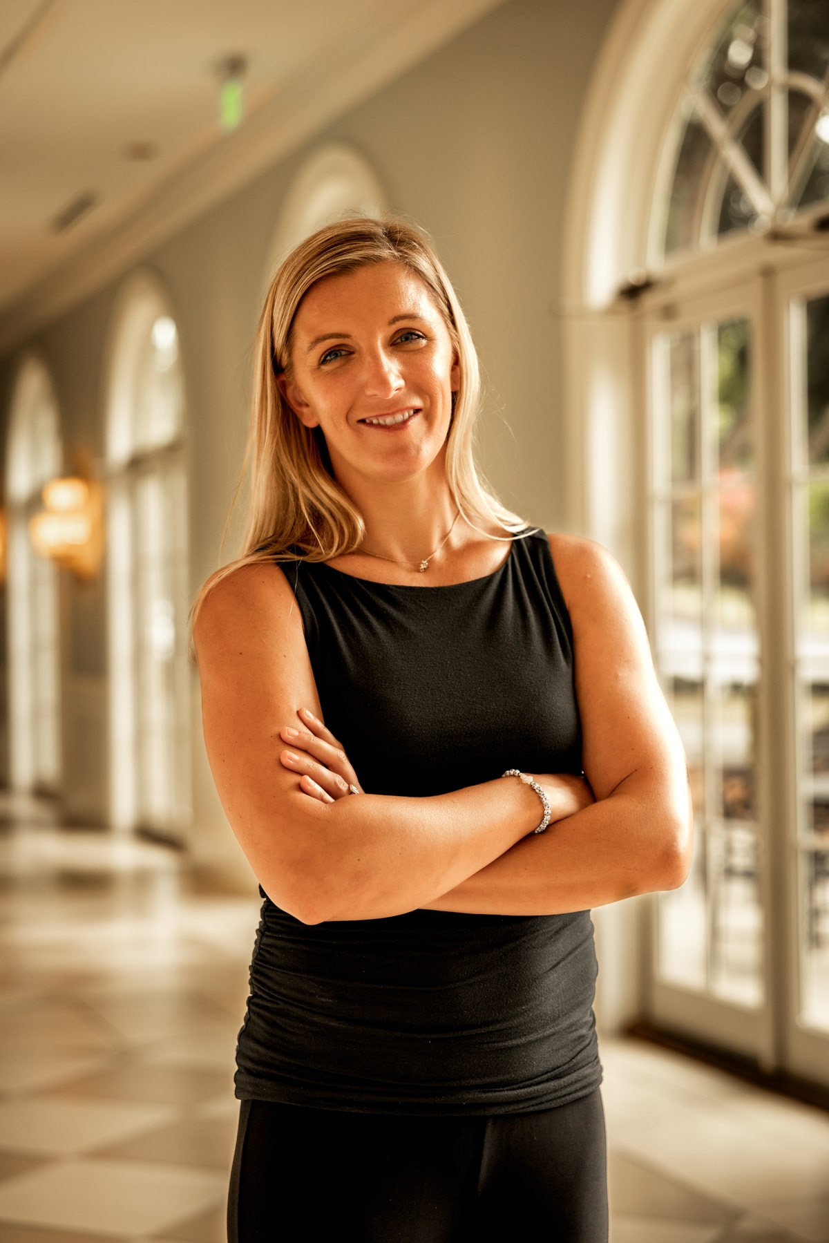 Regan Kulhavy, lawyer at the Law Office of Will M. Helixon, standing with arms crossed in an hallway