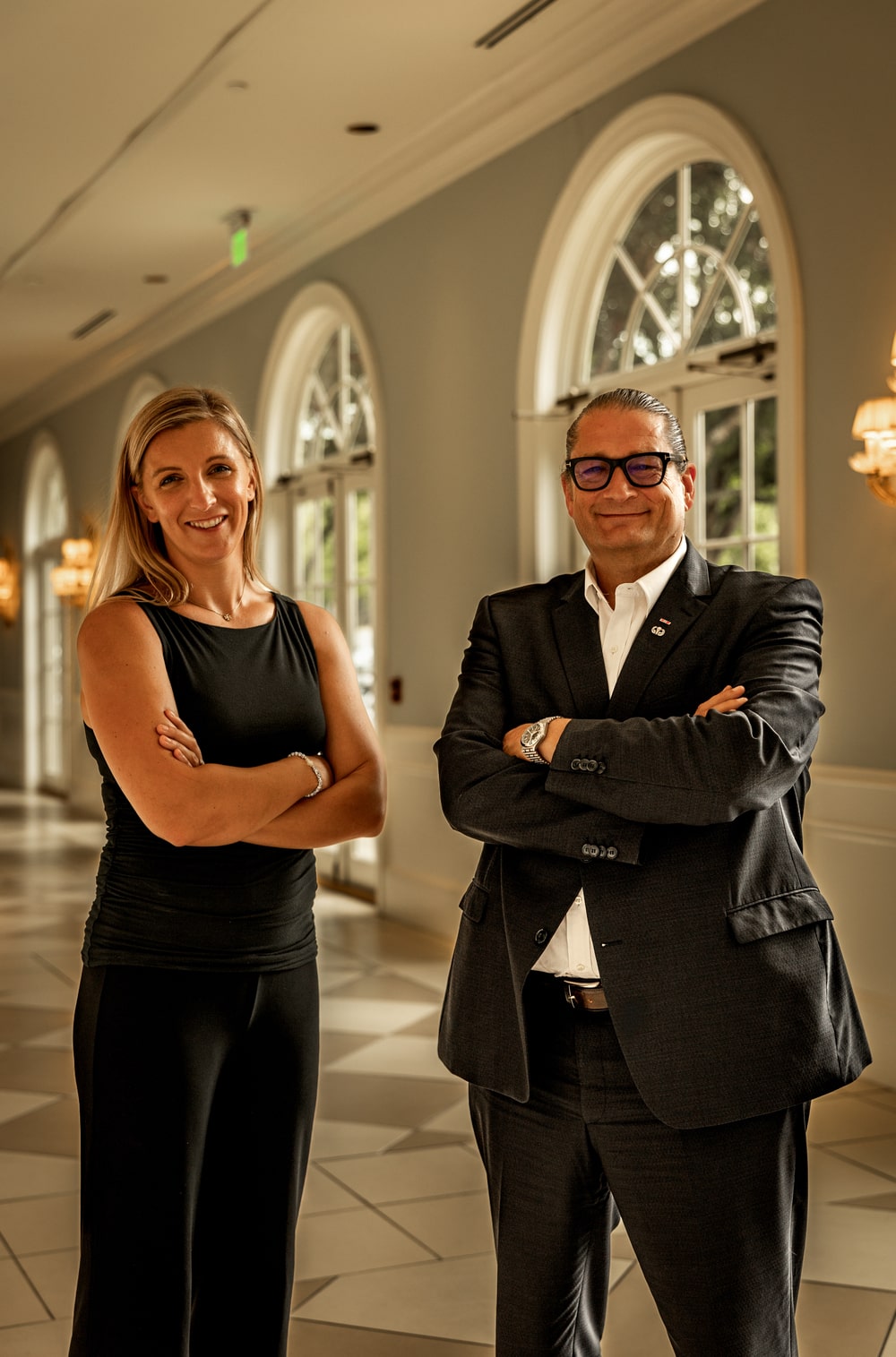 Regan Kulhavy and Will M. Helixon, lawyers at the Law Office of Will M. Helixon standing together in a hallway with arms crossed