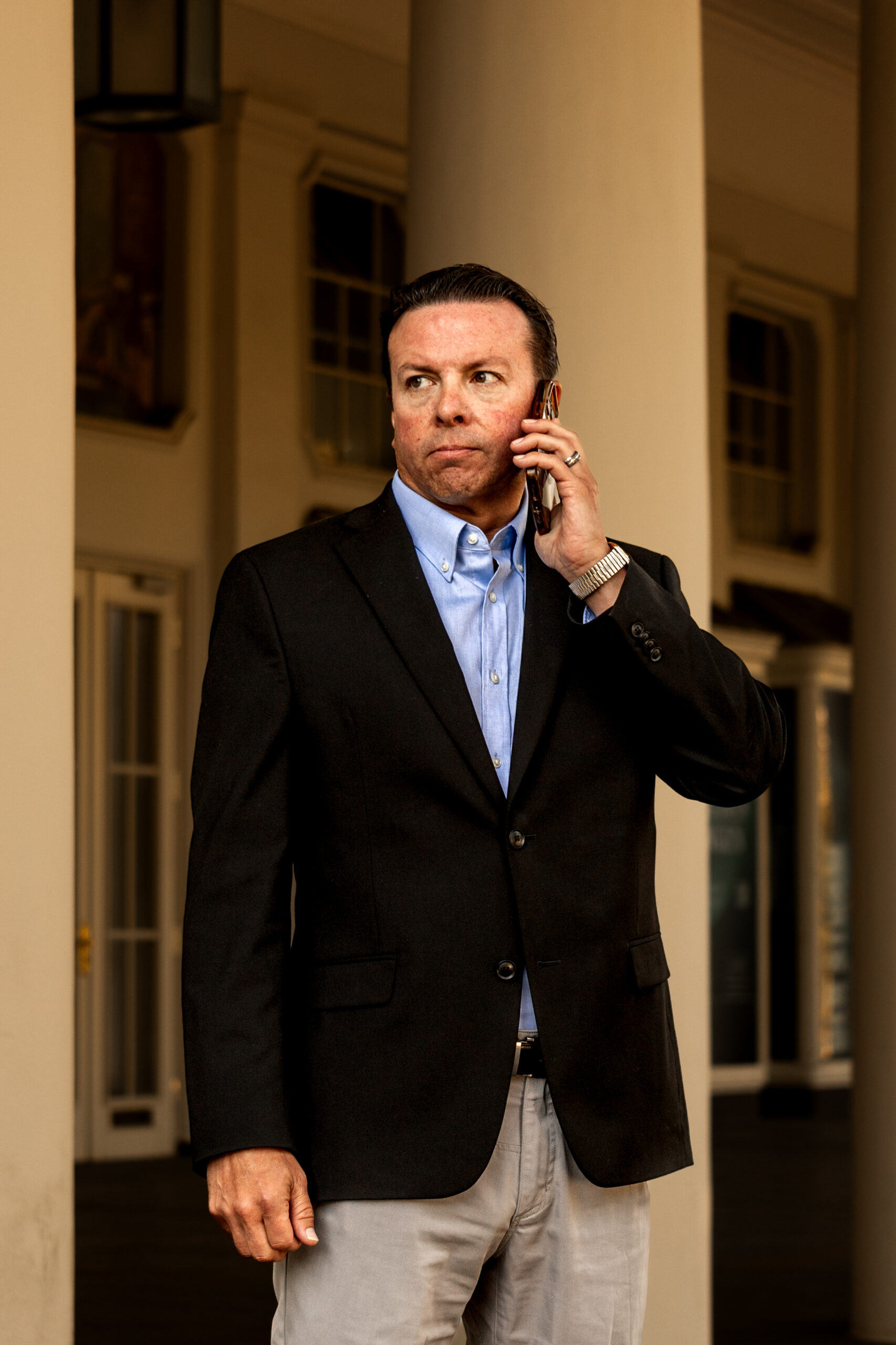 Andre Le Blanc in black blazer standing and talking on mobile phone