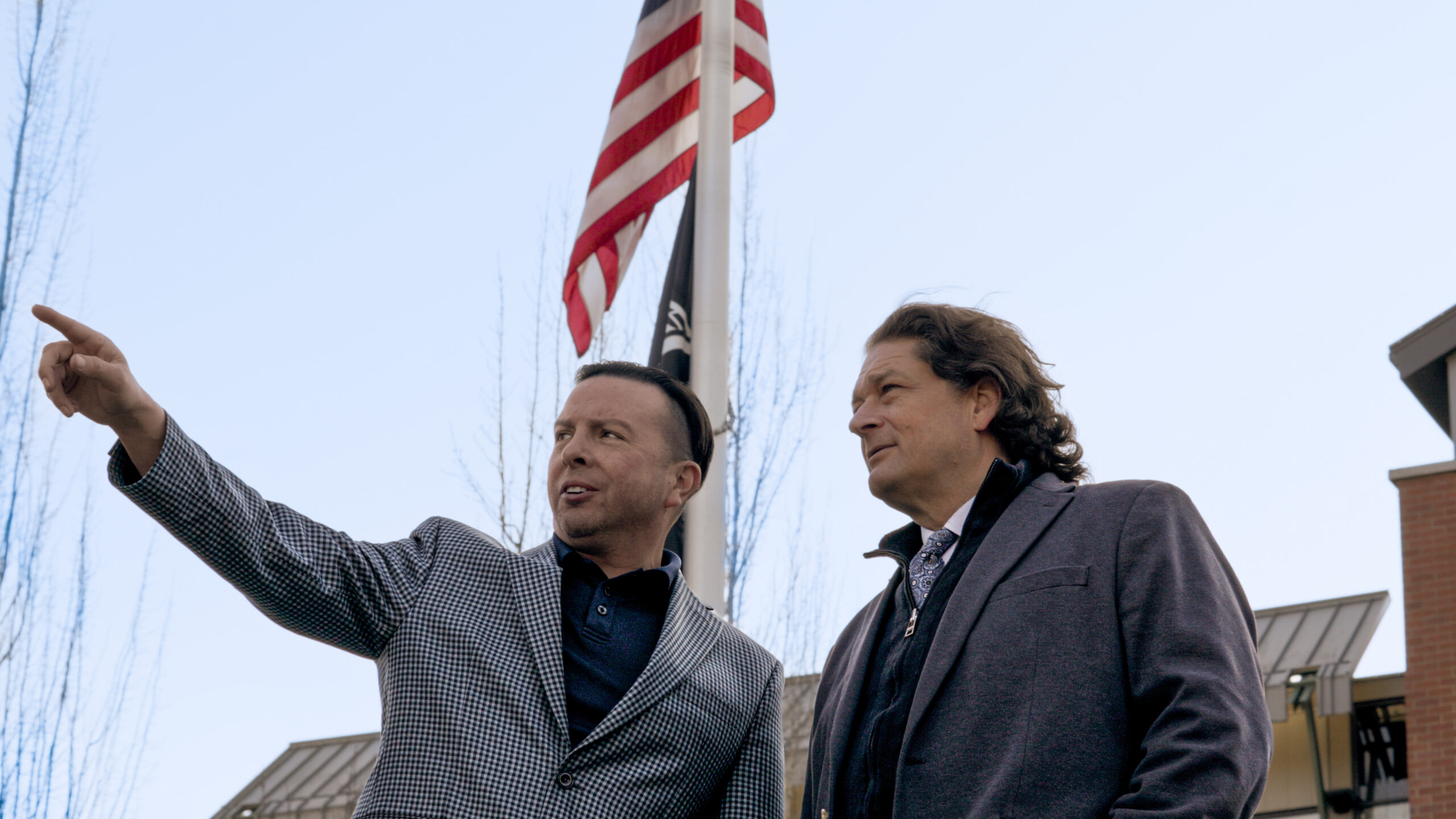 Andre Le Blanc and Will Helixon outdoors with American flag