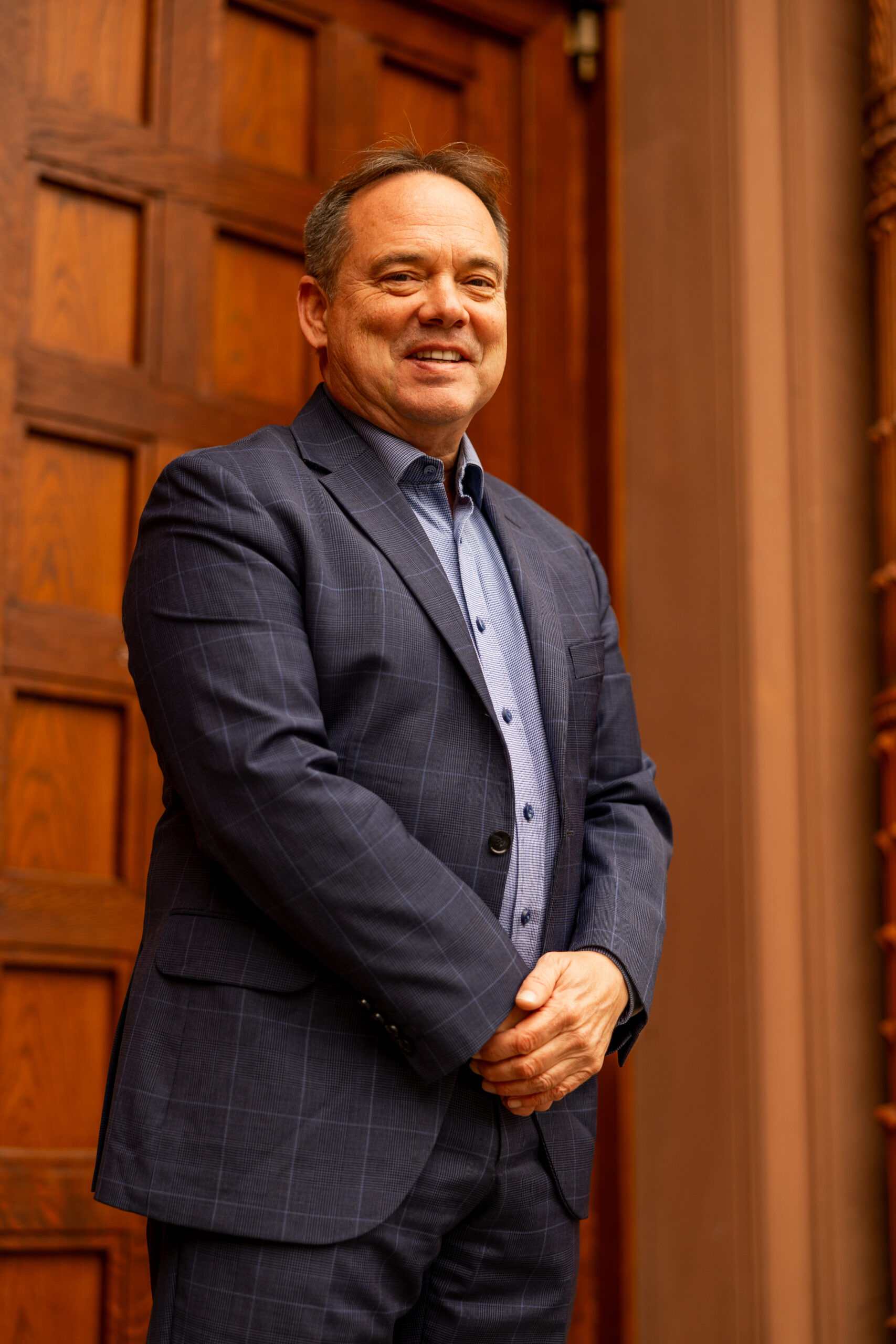 Scott Brokaw standing in front of wooden doors with hands clasped