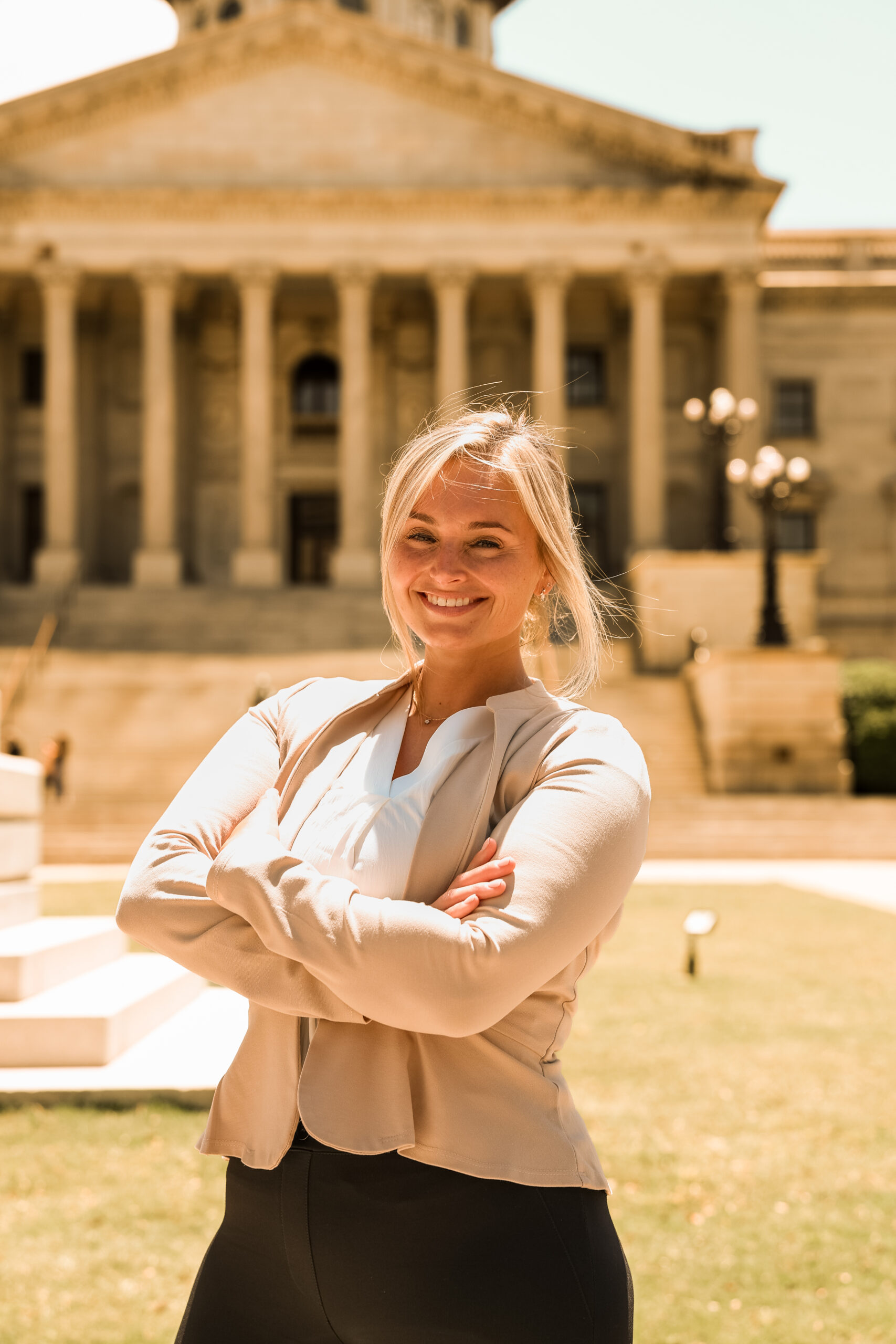 Stefany Garrick posing with arms crossed in front of a government building