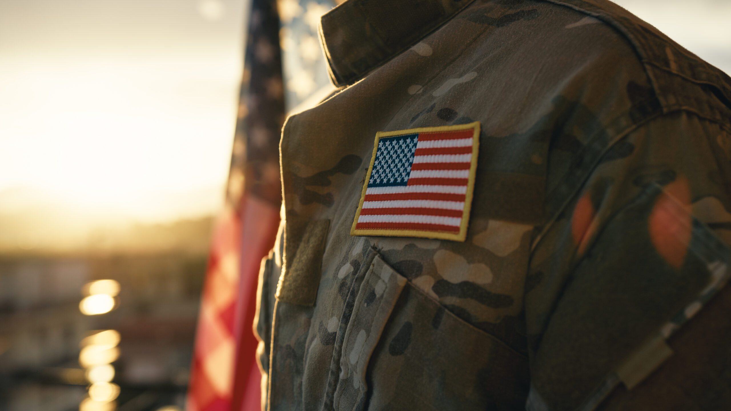 US military uniform displaying an American flag patch at sunset