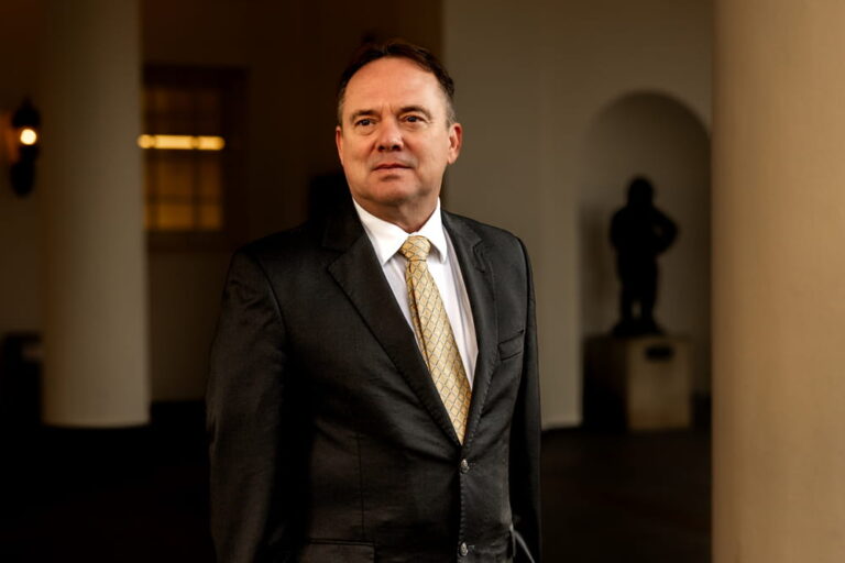 Scott Brokaw, military defense attorney at LOWMH, in a dark suit with gold tie