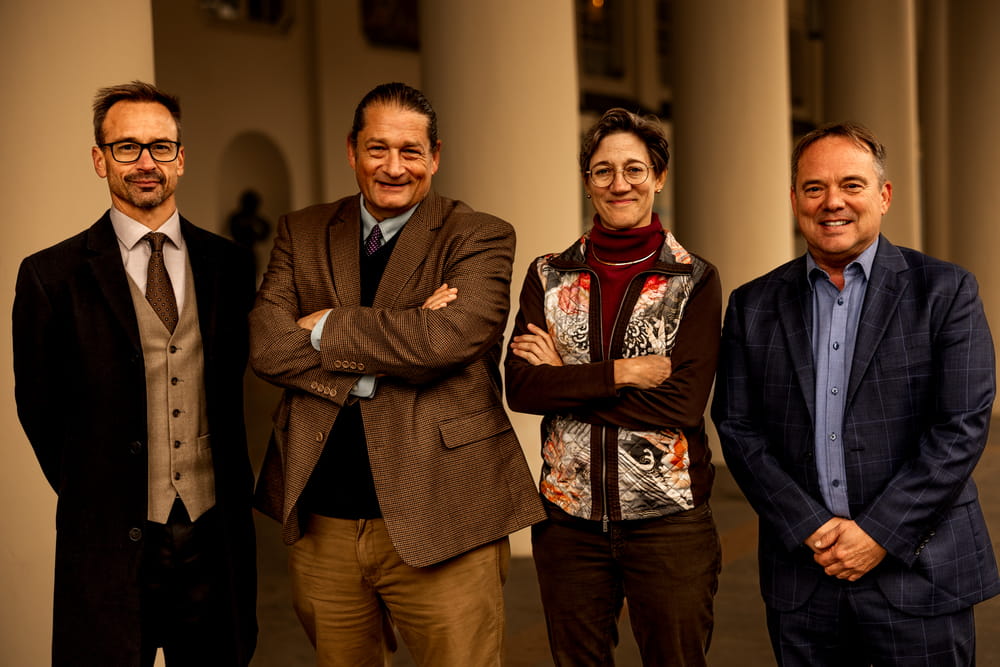 Four military lawyers from the Law Office of Will M. Helixon smiling and posing together outside a courthouse
