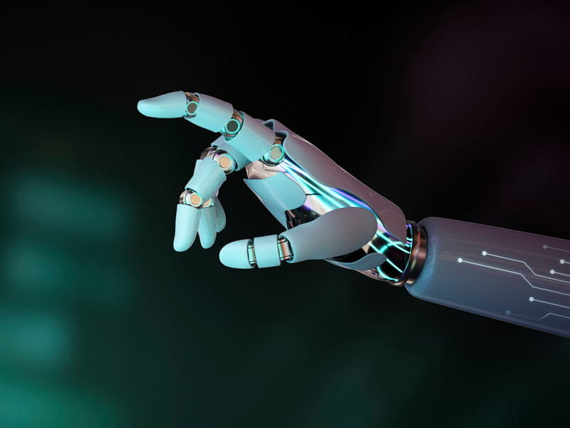 Close-up of a white and chrome robotic hand with index finger extended against a dark green background
