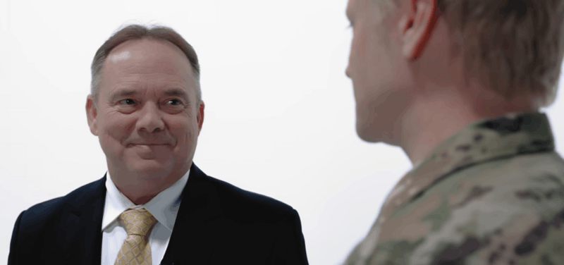 Service member in uniform speaking privately with his military defense attorney about his case