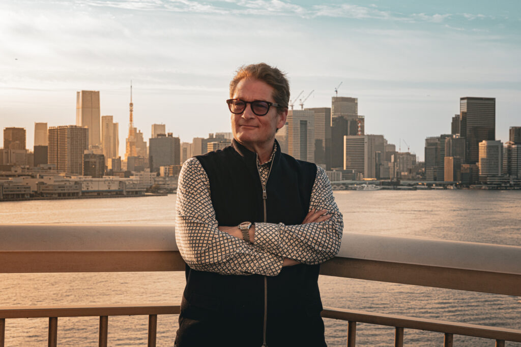 Military defense lawyer in Japan Will M. Helixon at a Tokyo Bay railing, Tokyo Tower in the skyline behind him